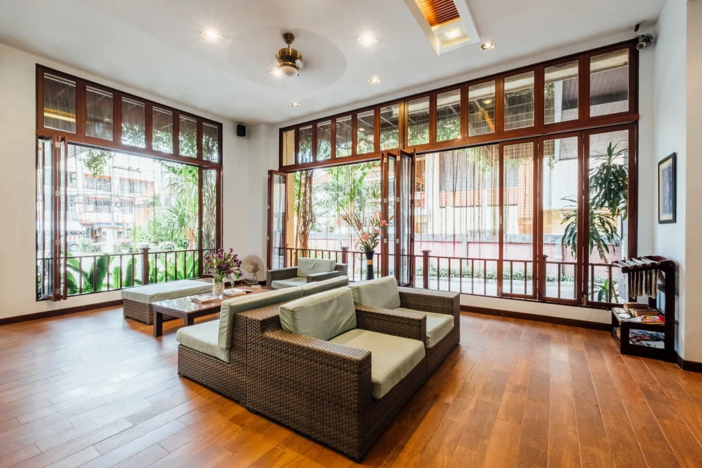 Bright bungalow living room with downlit ceiling and folding glass doors — Hypro renovation