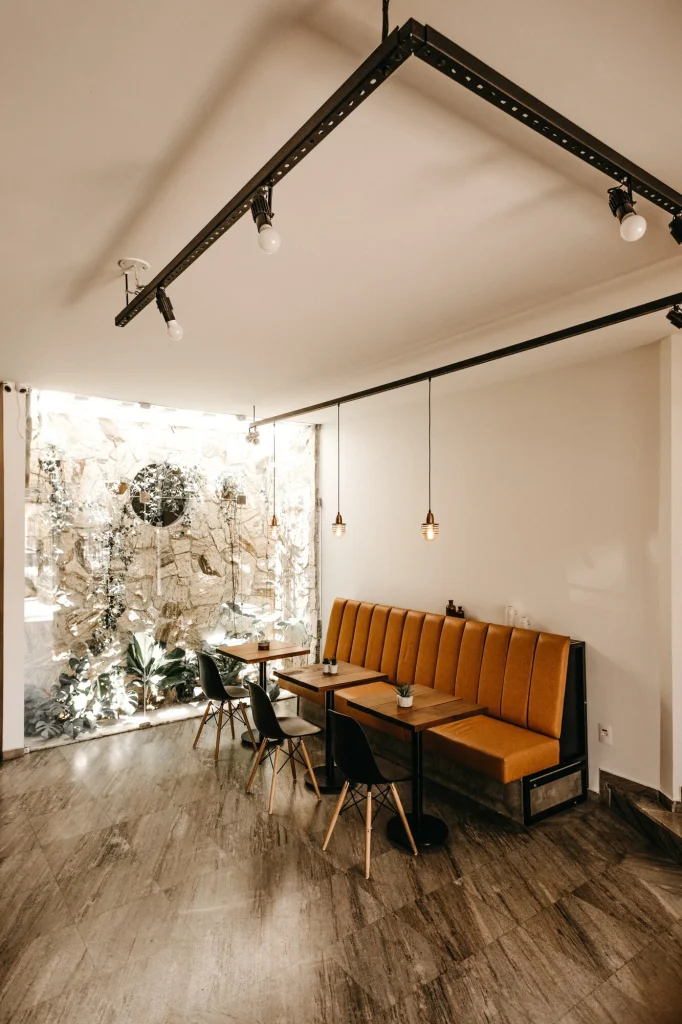Café interior with exposed black track-lighting ceiling rail and pendant lights — commercial ceiling fit-out by Hypro