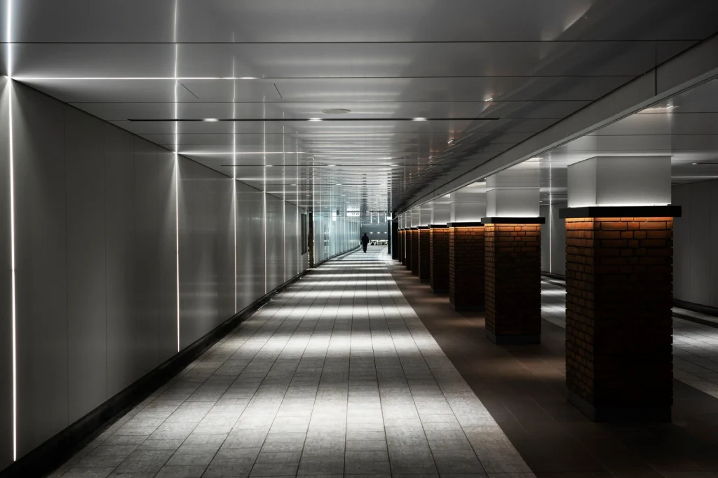 Modern corporate corridor with linear recessed LED ceiling lighting — Hypro ceiling and partition work