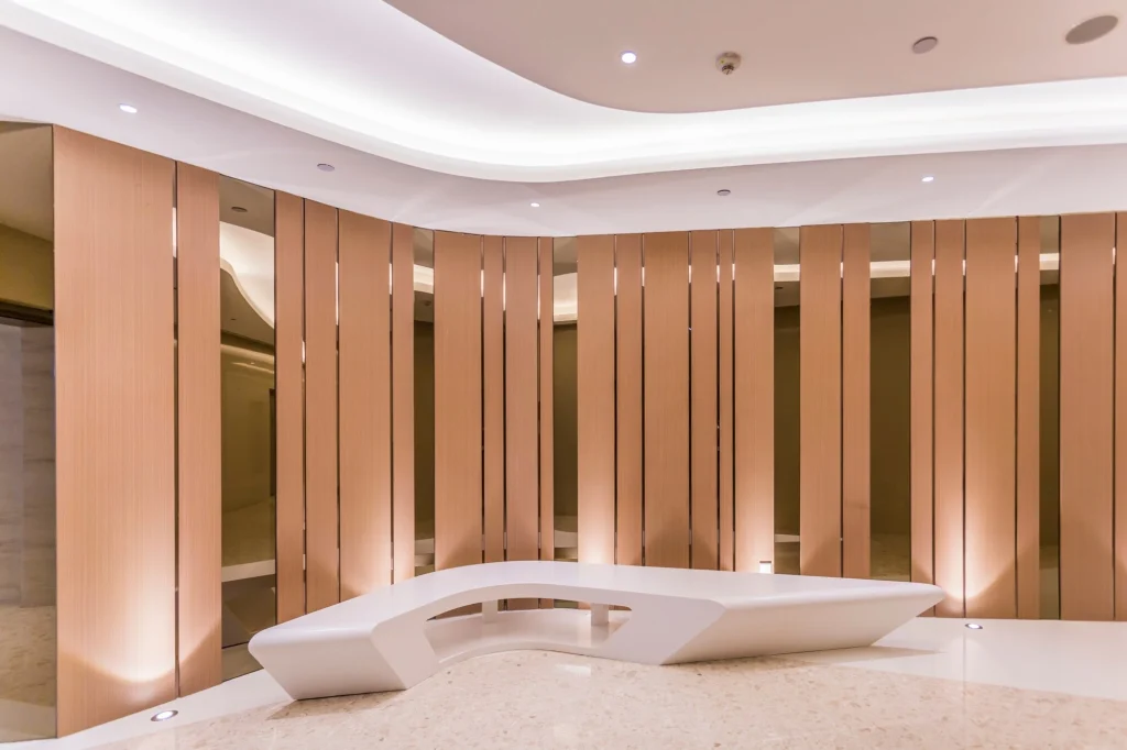 Luxury retail lobby with timber-slat feature wall and curved cove plaster ceiling — Hypro ceiling work
