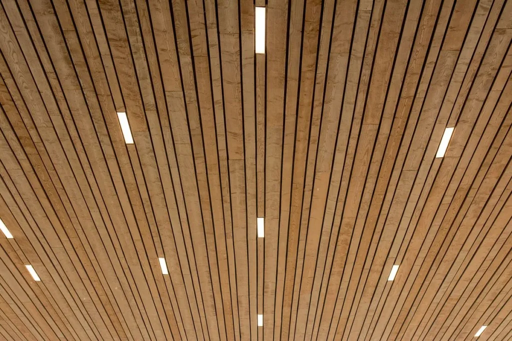 Aluminium baffle ceiling with linear slats and integrated lighting
