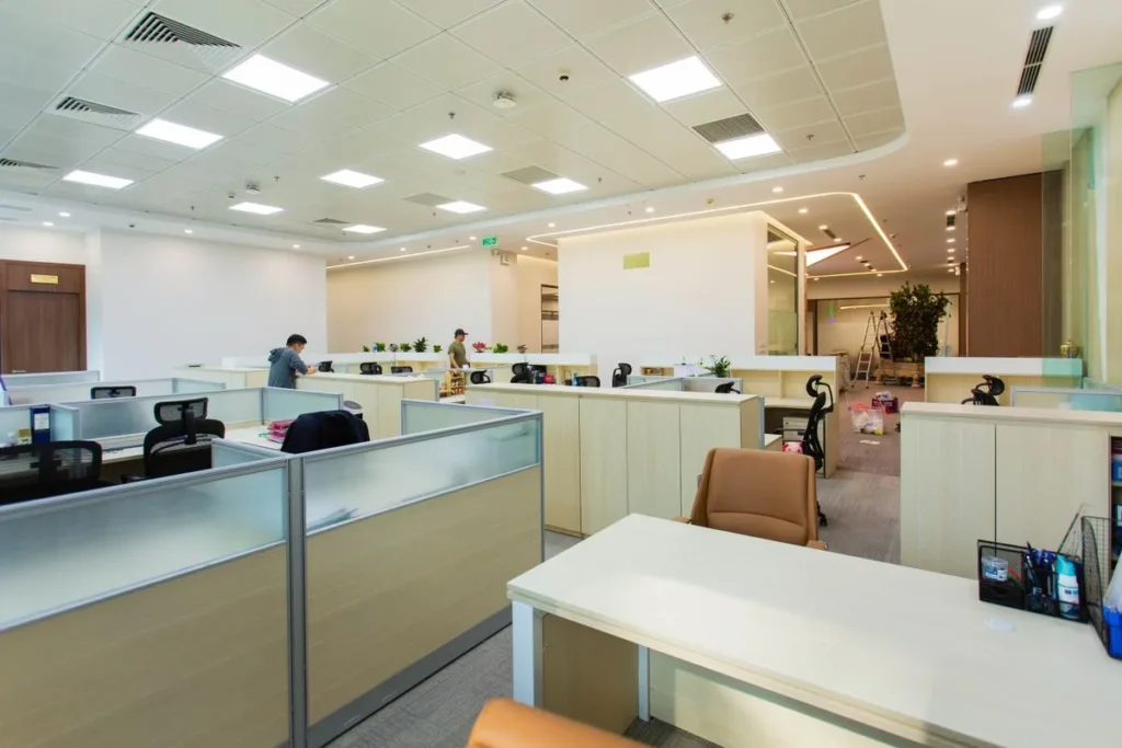 Office with plaster ceiling bulkheads and suspended ceiling panels over workstations
